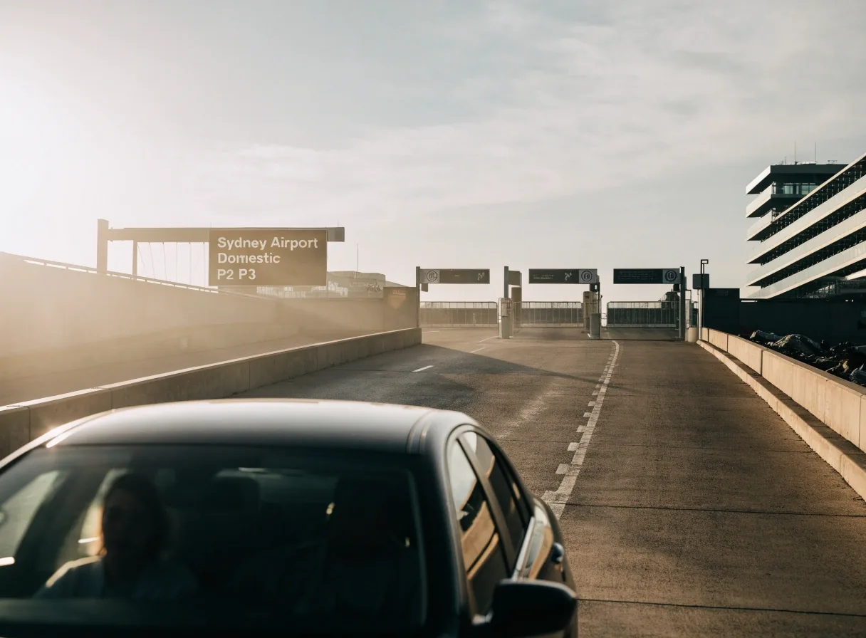 Car approaching the entrance ramp of the airport car park in morning light